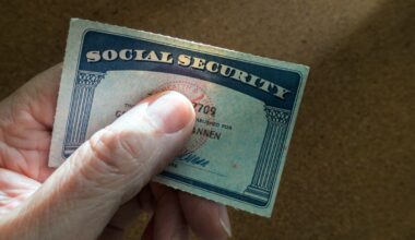 A hand is shown, holding a Social Security card.