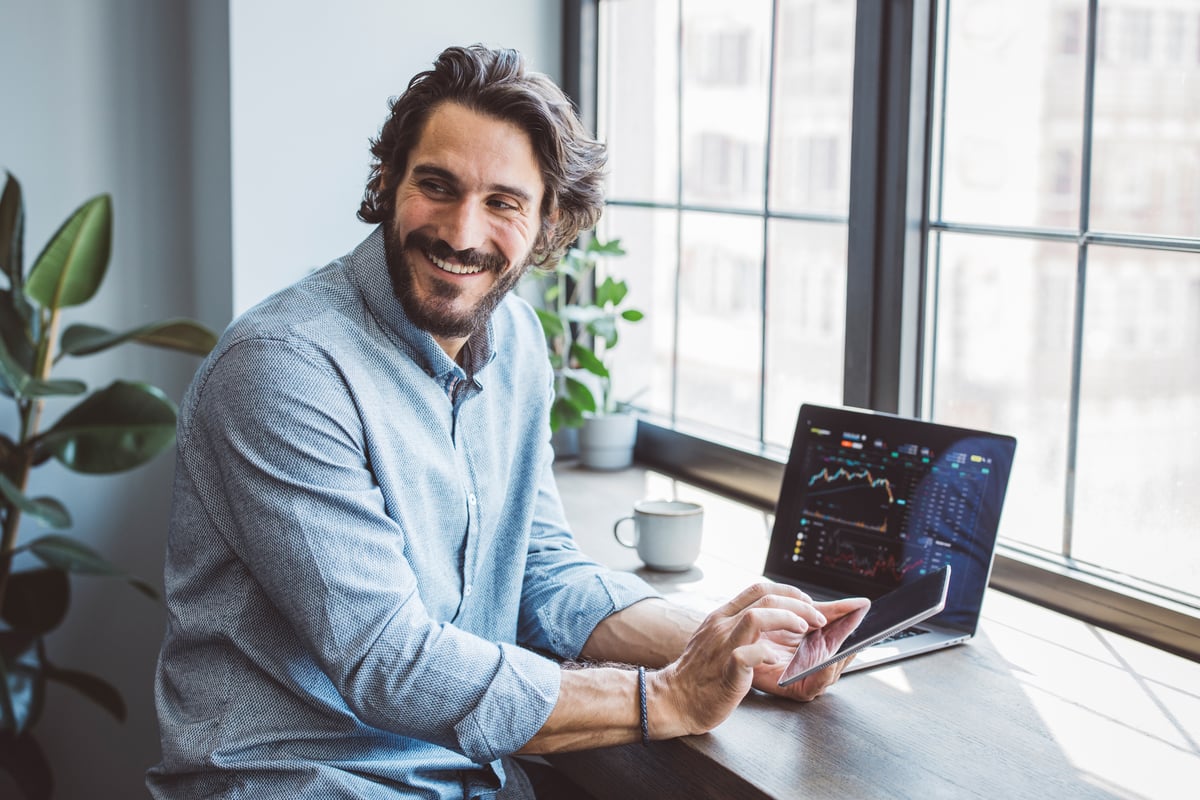 An investor sits at a desk and smiles.