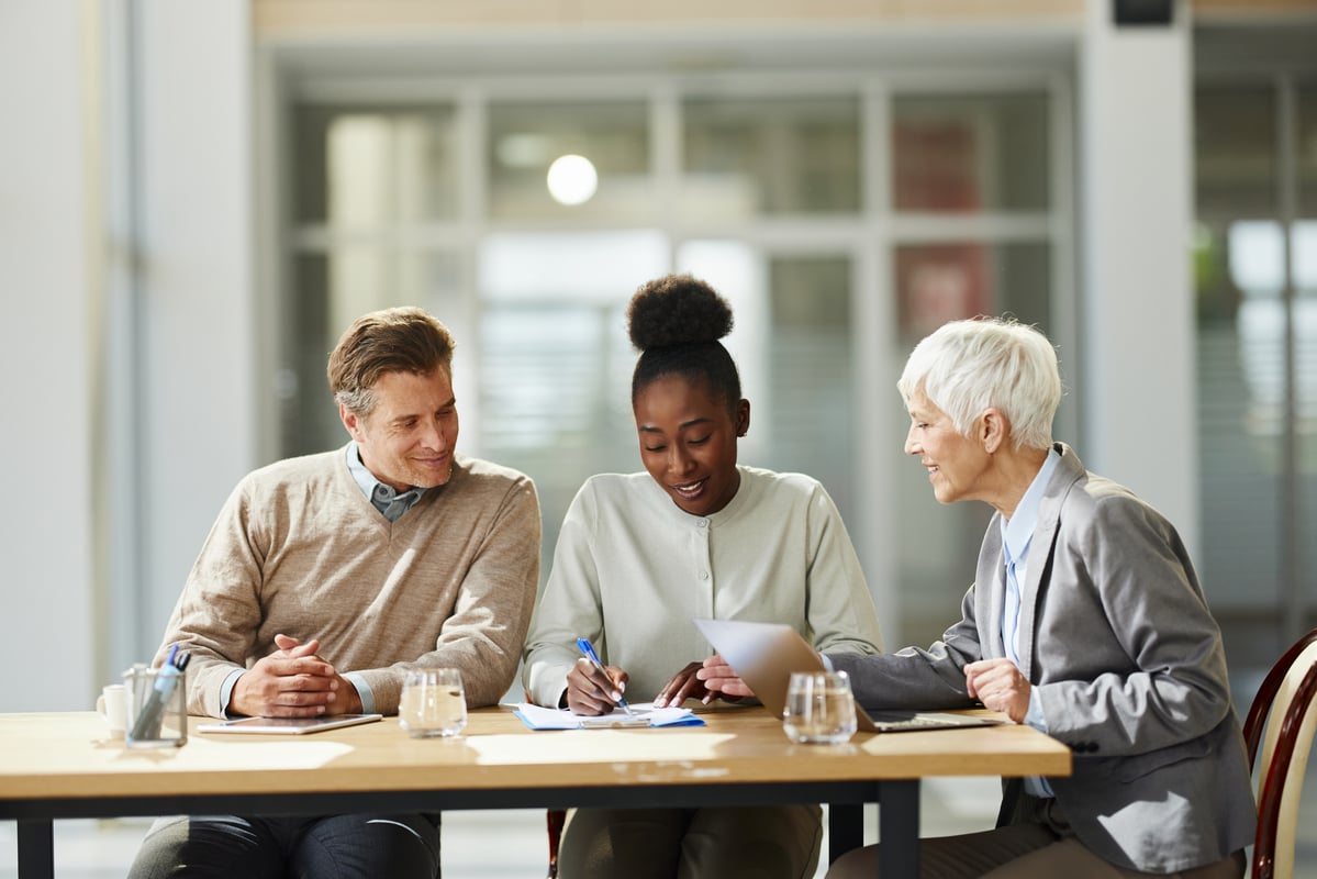 Professional sitting with clients in a meeting.