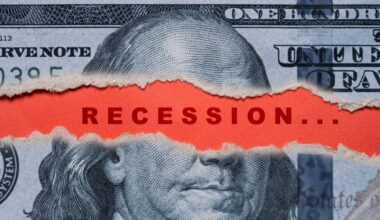 U.S. currency torn to reveal the word "recession" written in alarming red text.