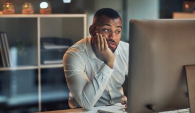 Person with a serious expression looking at a computer.