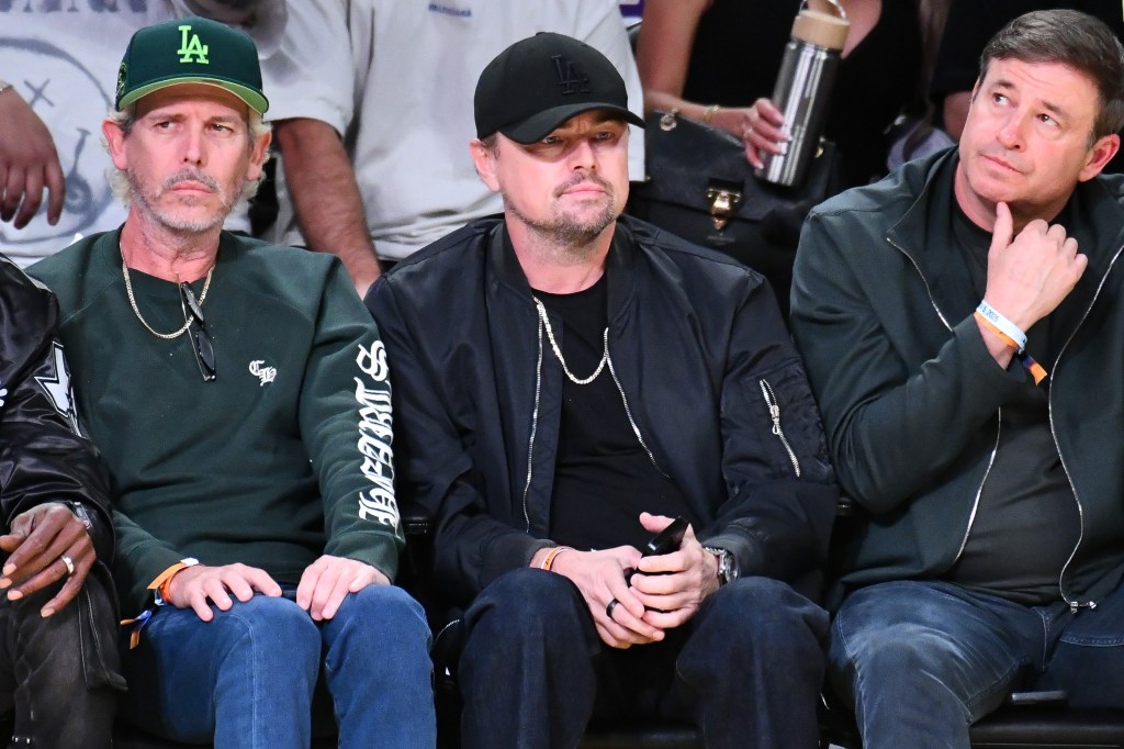Leonardo DiCaprio (center), Todd Graves (left), and an unidentified man watching a basketball game.