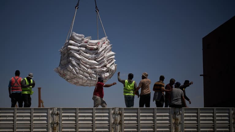 Workers offload cargo of rice from a feeder vessel into trucks at Umm Qasr Port, a deep-water port, in the city of Umm Qasr, Iraq, Friday, March 27, 2026.