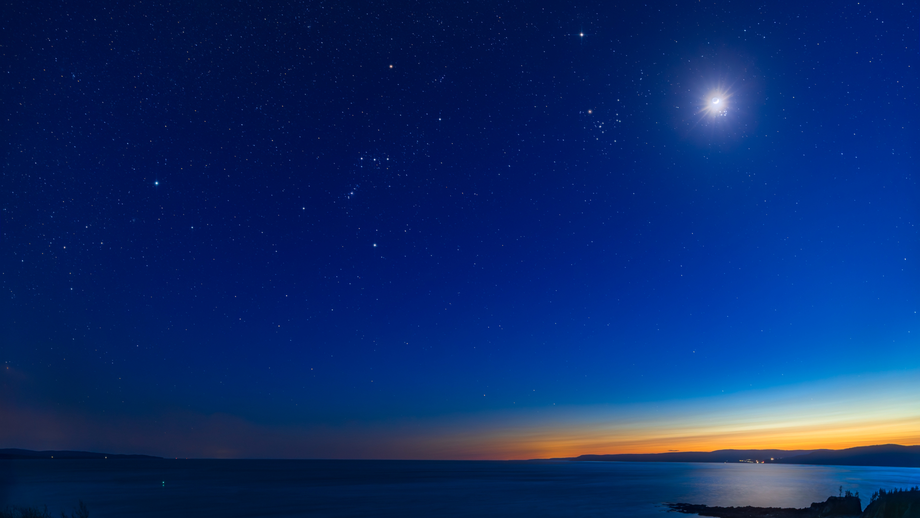 The moon is shown glowing in the evening sky with the stars of the constellations Taurus and Orion to its left, and the brightest stars of the Pleiades open star cluster close below.