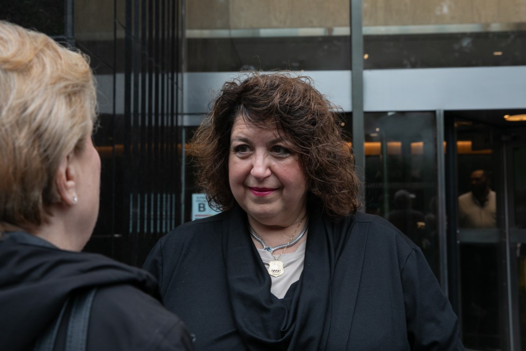 City retiree leader Marianne Pizzitola speaks at a fellow protester against the Medicare Advantage plan.