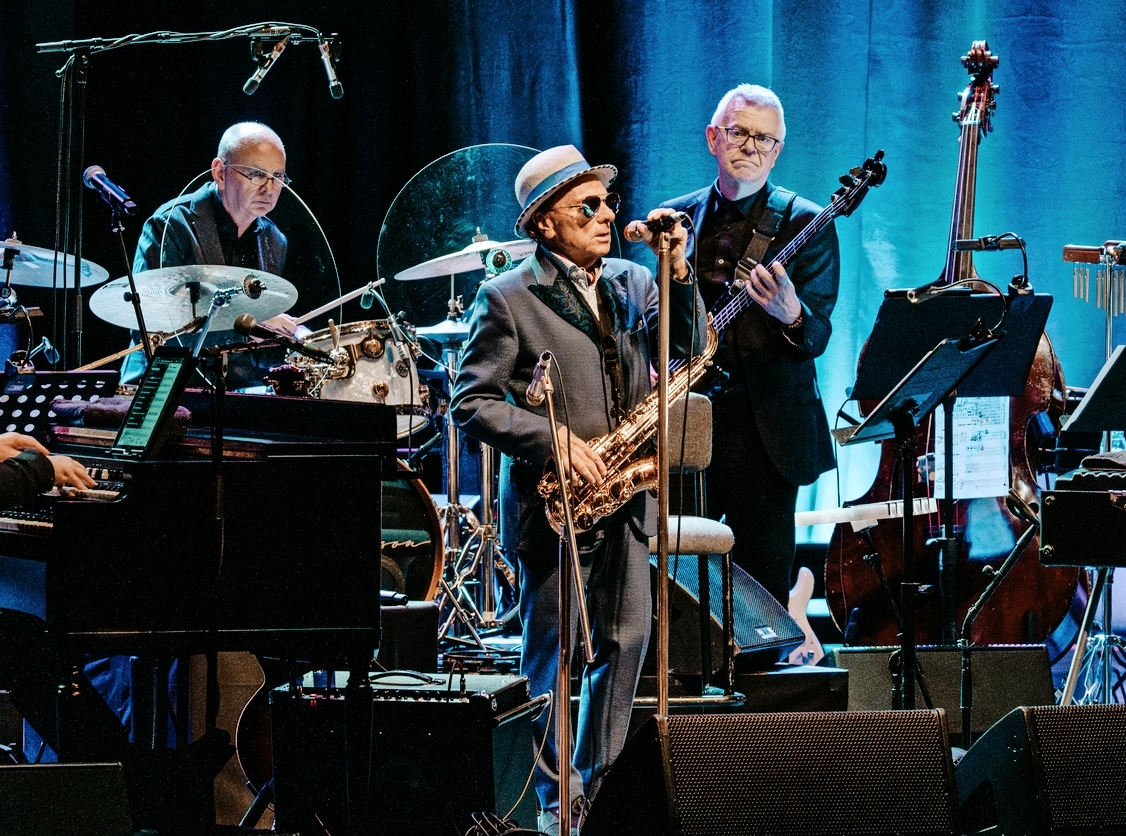 Van Morrison performing live on stage with his band.