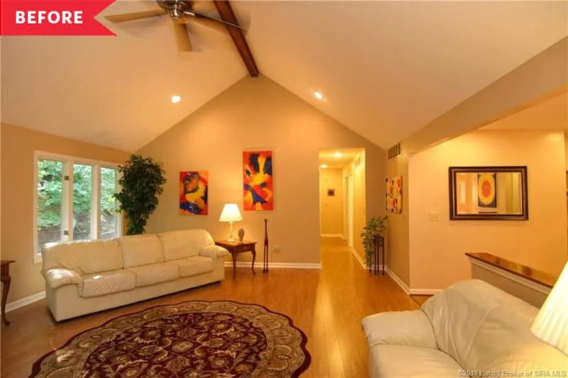 Before: Back wall of large living room with beige walls and honey oak floors