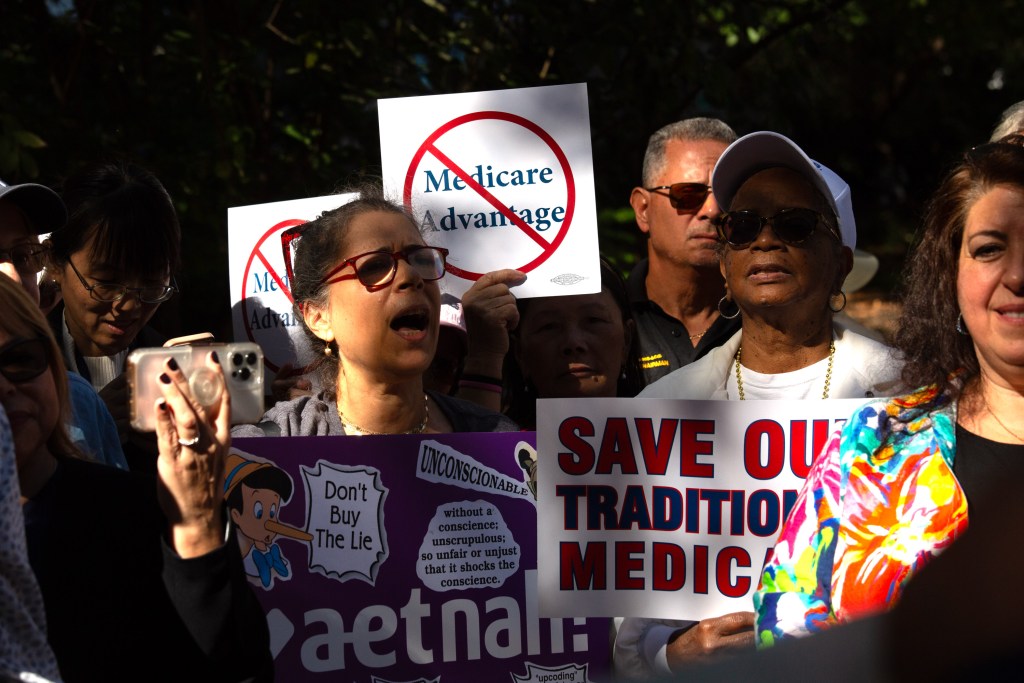 Retired city workers rally outside City Hall against a plan to change their healthcare plans.
