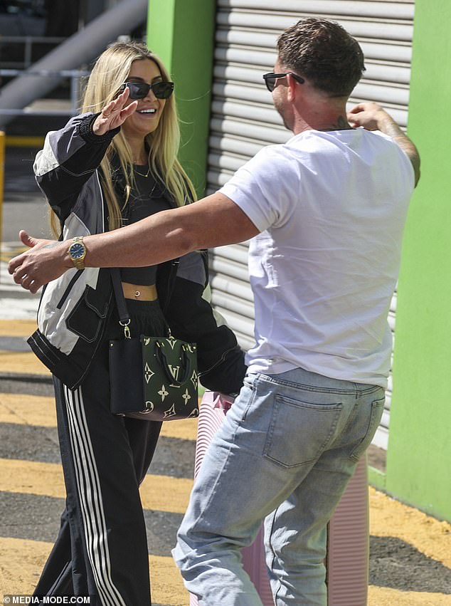 Gia beamed as Chris opened his arms wide to greet her, the two sharing a warm hug beside the suitcase