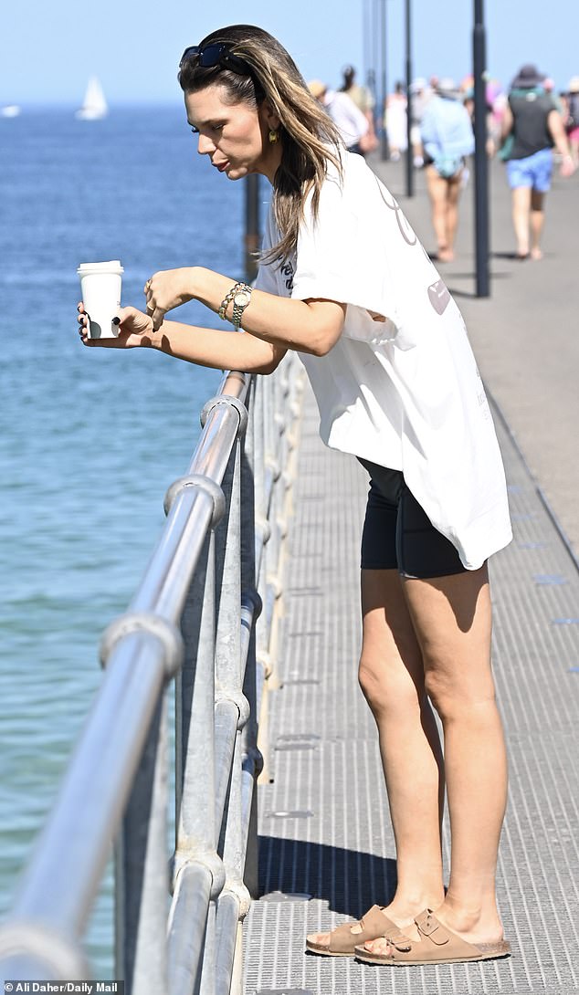 At one point, for her day in the sun, Bec was seen leaning against a guardrail, lost in thought while she took in the view. (Pictured)