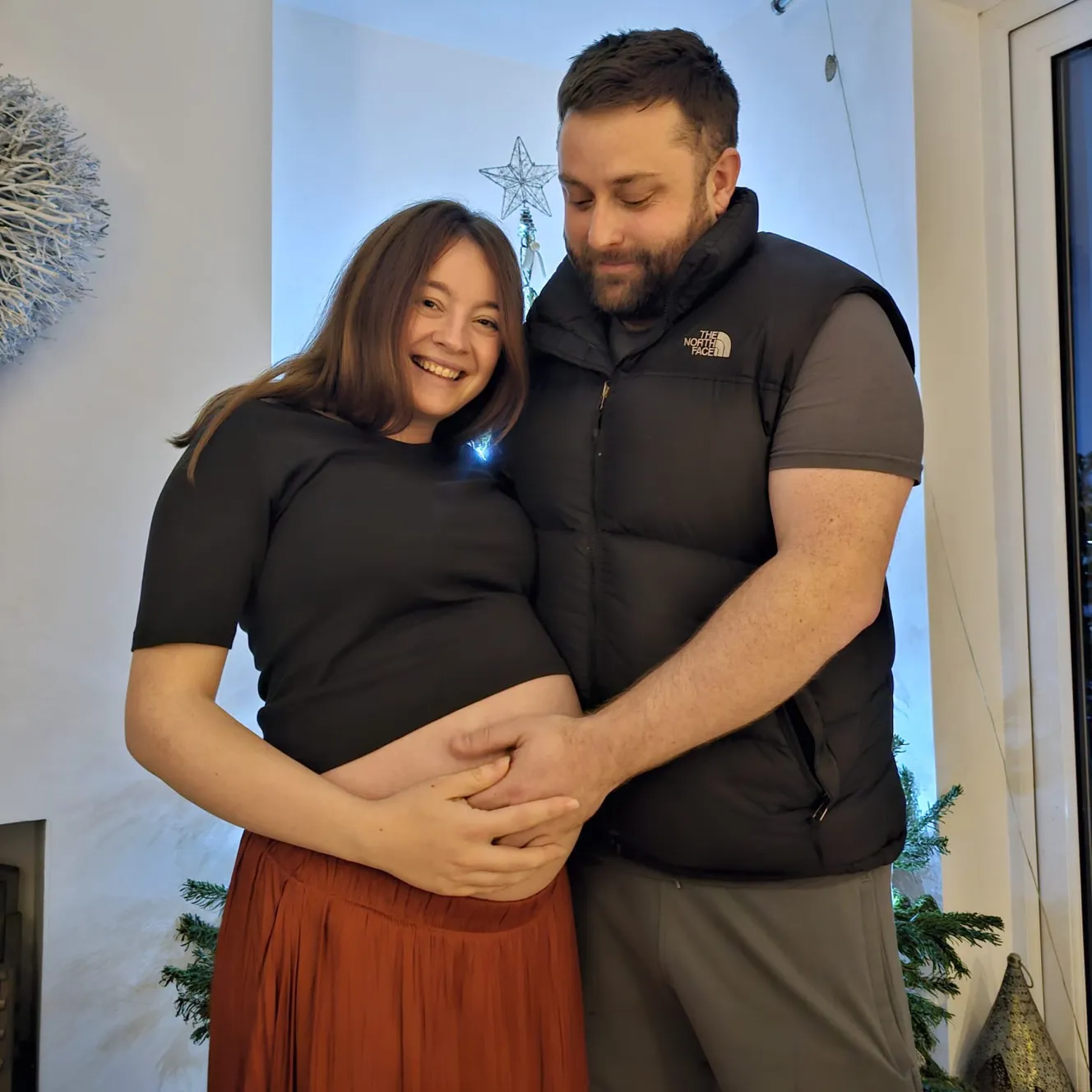 Maisie Ransom and her husband Keith Ransom, with Keith holding Maisie's pregnant belly.