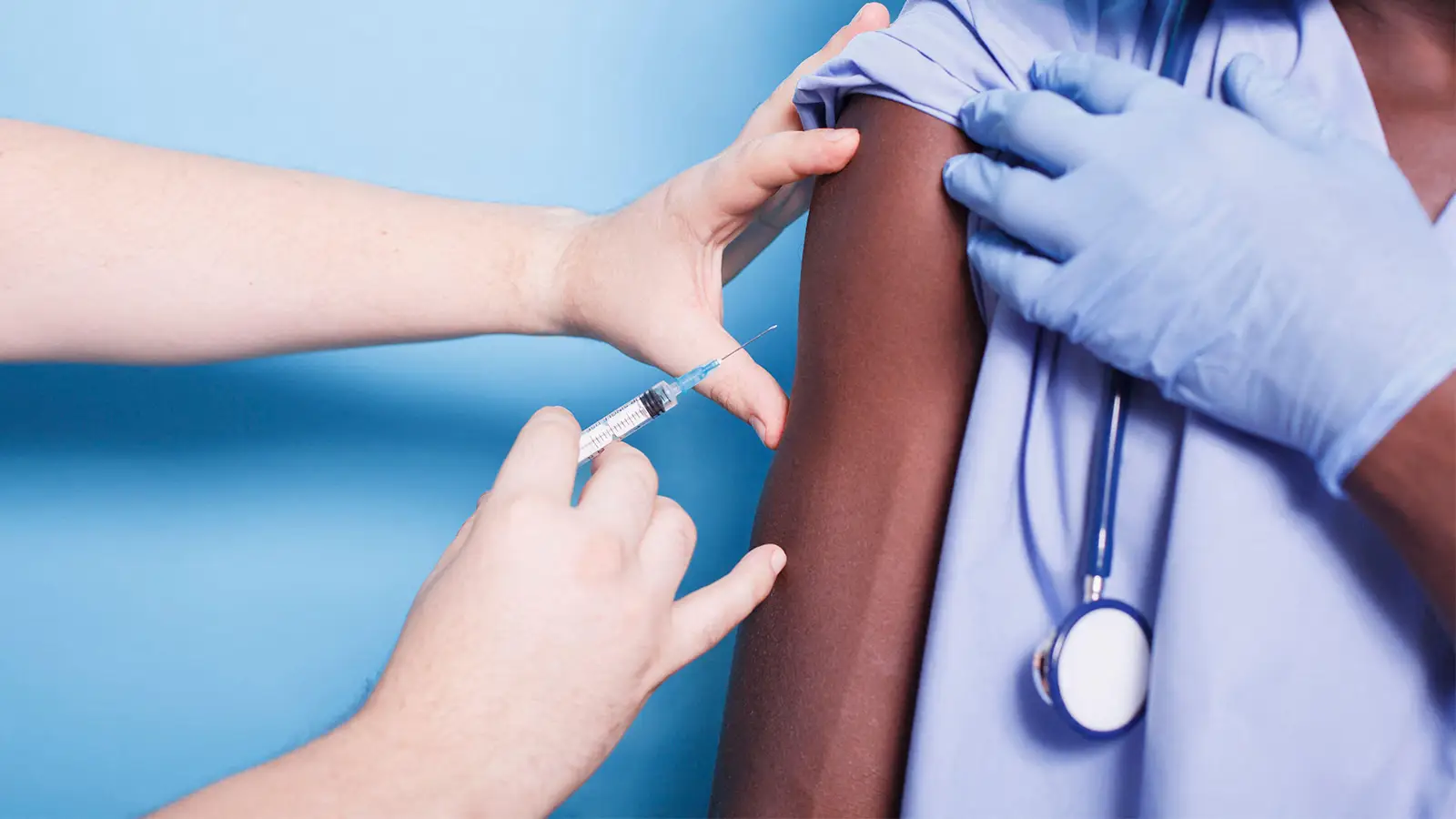A photo of a female healthcare worker getting vaccinated.