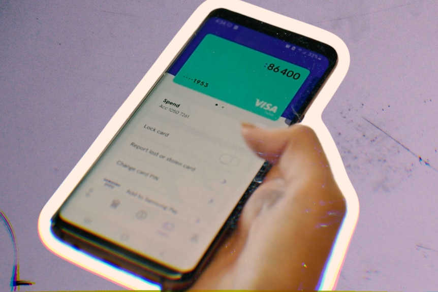 A hand holds a mobile phone with a credit card visible on the screen.