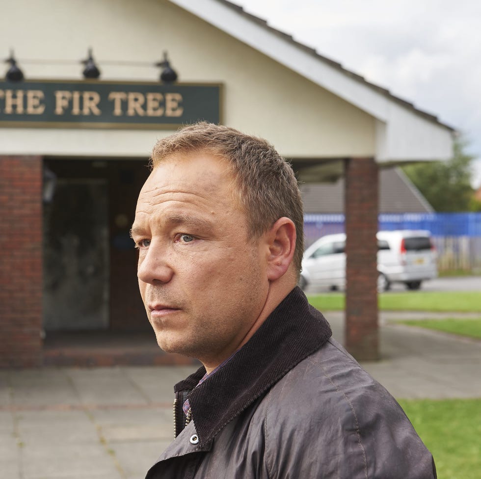 outdoor scene featuring a man in front of a building named the fir tree