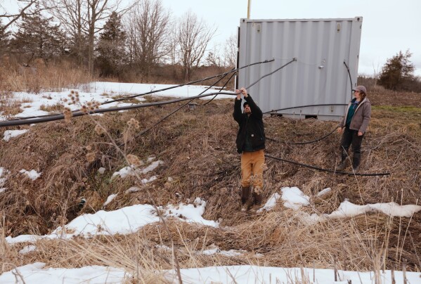 Joshua Faulkner, left, research associate professor and director of the Agricultural and Environmental Testing Lab at the University of Vermont, and graduate student Delaney Bullock check on flumes used to collect runoff from two agriculture fields for analysis on Thursday, March 12, 2026, in Bridport, Vt. (AP Photo/Amanda Swinhart) (AP Photo/Amanda Swinhart)