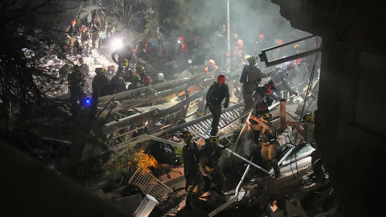 Israeli security forces and rescue teams work amid the rubble of a residential building struck by an Iranian missile in Haifa, Israel, Sunday, April 5, 2026.