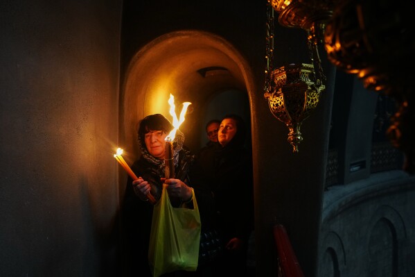 Christian Orthodox pilgrims hold up candles during the Holy Fire ceremony, at the Church of the Holy Sepulcher, the site where, according to tradition, Jesus was crucified and buried, in the Old City of Jerusalem, Saturday, April 11, 2026. (AP Photo/Mahmoud Illean)