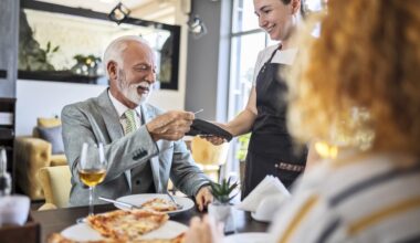 Father having pizza with daughter in restaurant ,paying bill stock photo