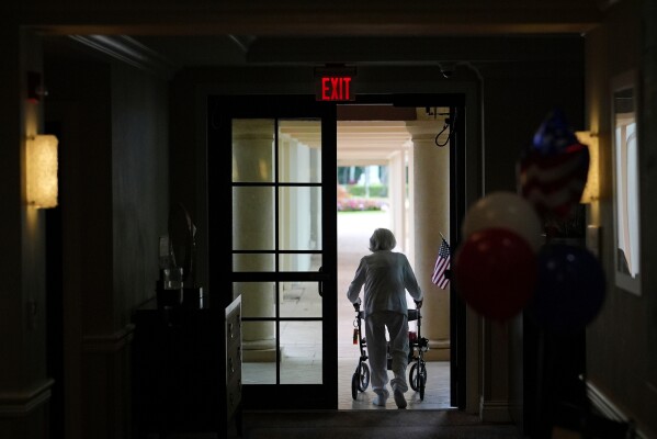 A woman uses a walker as she exits an assisted living building at the Toby and Leon Cooperman Sinai Residences, July 4, 2025, in Boca Raton, Fla. (AP Photo/Rebecca Blackwell, File)
