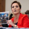 Kari Lake, who led Voice of America's parent agency for much of last year, holds up a photo of the international broadcaster's newsroom during a House Foreign Affairs Committee hearing on June 25, 2025.