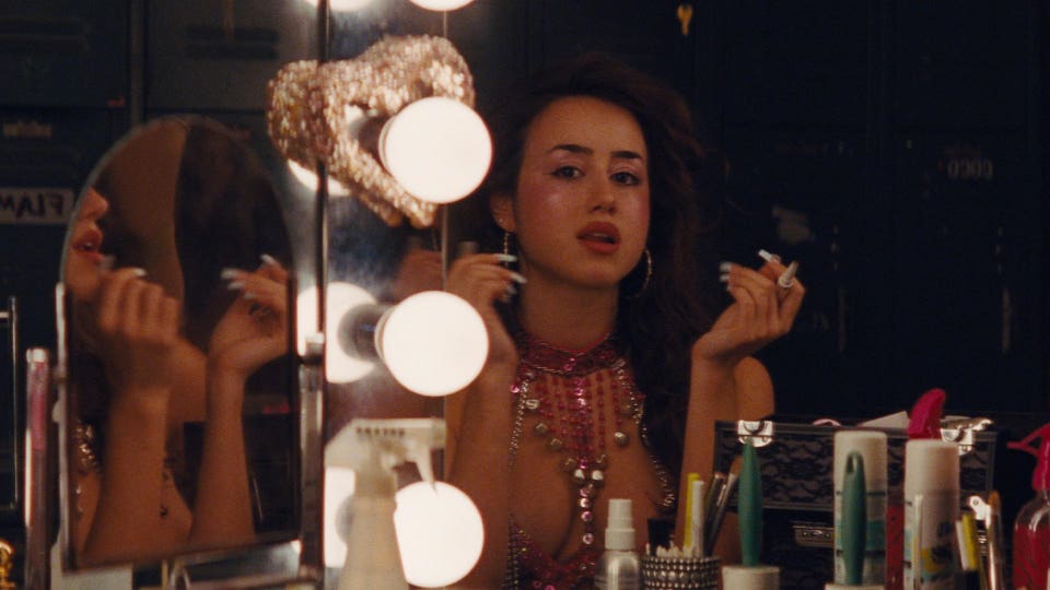 Angel is looking in the mirror of her vanity at the Silver Slipper.