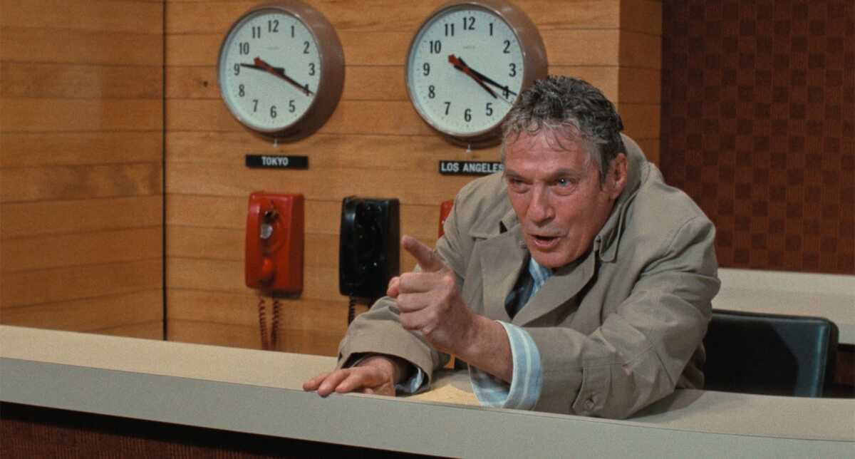 A news anchor shouts at his television audience.