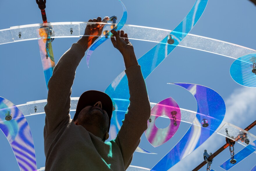 Jamal Hussein works on his piece, ‘New Light,’ at the Odom Pavilion in Austin, Texas, on April 6, 2026. Joe Ferrara / KUT News