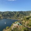 A town nestled in a cove where green hills meet the blue sea.