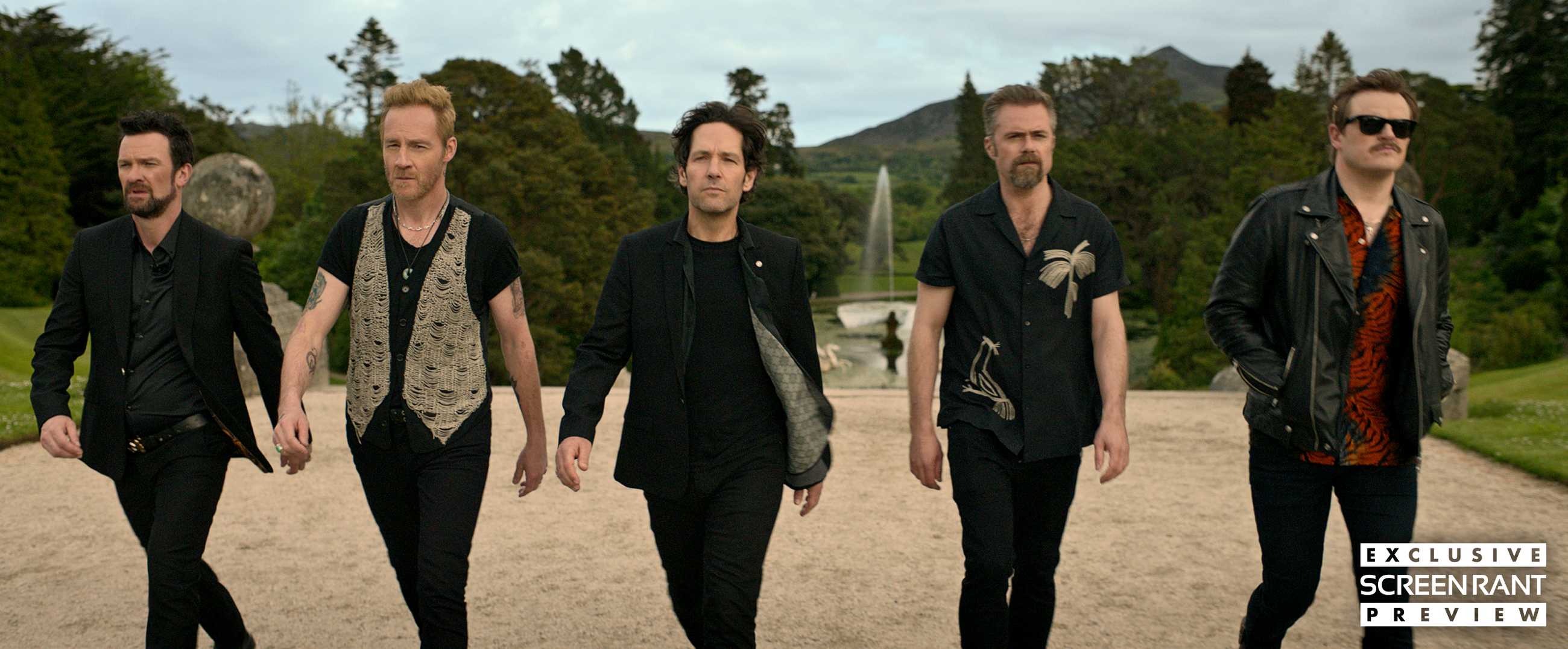Paul Rudd leading a group of men in matching outfits walking in a line in Power Ballad