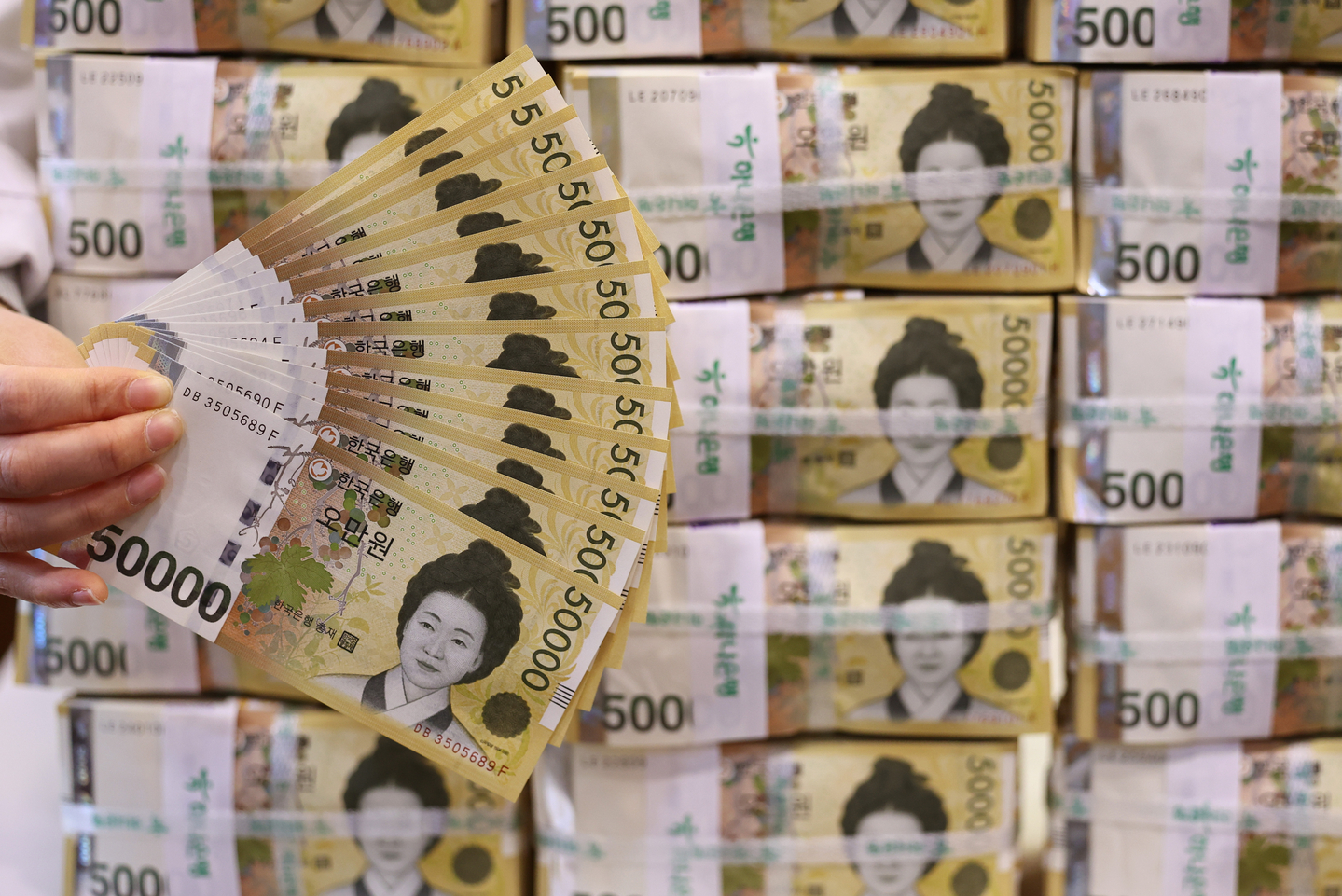 An employee sorts 50,000-won banknotes at a Hana Bank in Jung District, central Seoul, on March 24. [NEWS1]