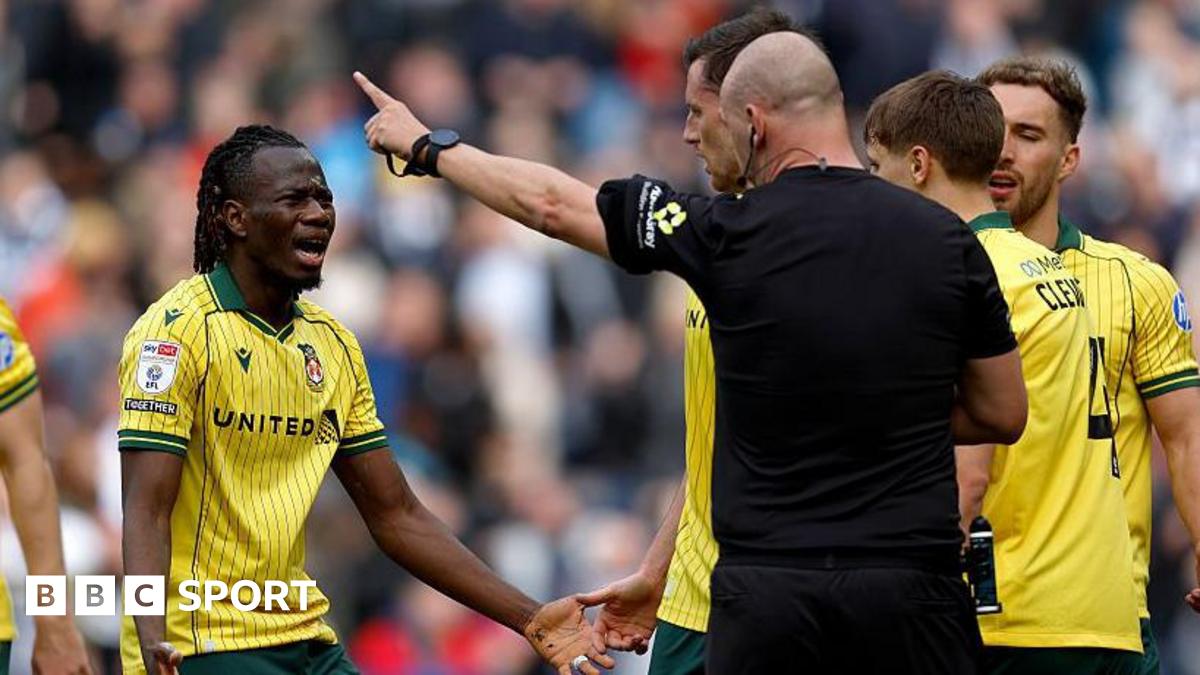 Wrexham's Issa Kabore (left) protests with referee Robert Madley