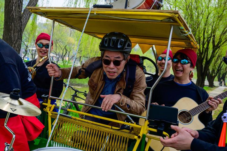 Kim Sang-jun, a 60-year-old passerby, poses with Dongmi Bicycle Club on the band's quadracycle during an interview with The Korea Times at Han River Park in Seoul, April 3. Korea Times photo by Choi Won-suk
