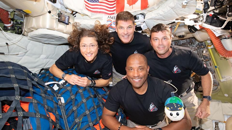 Art002e013365 (April 7, 2026) – The Artemis II crew – (clockwise from left) Mission Specialist Christina Koch, Mission Specialist Jeremy Hansen, Commander Reid Wiseman, and Pilot Victor Glover – pause for a group photo with their zero gravity indicator "Rise," inside the Orion spacecraft on their way home. Following a swing around the far side of the Moon on April 6, 2026, the crew exited the lunar sphere of influence (the point at which the Moon's gravity has a stronger pull on Orion than the Earth's) on April 7, and are headed back to Earth for a splashdown in the Pacific Ocean on April 10.