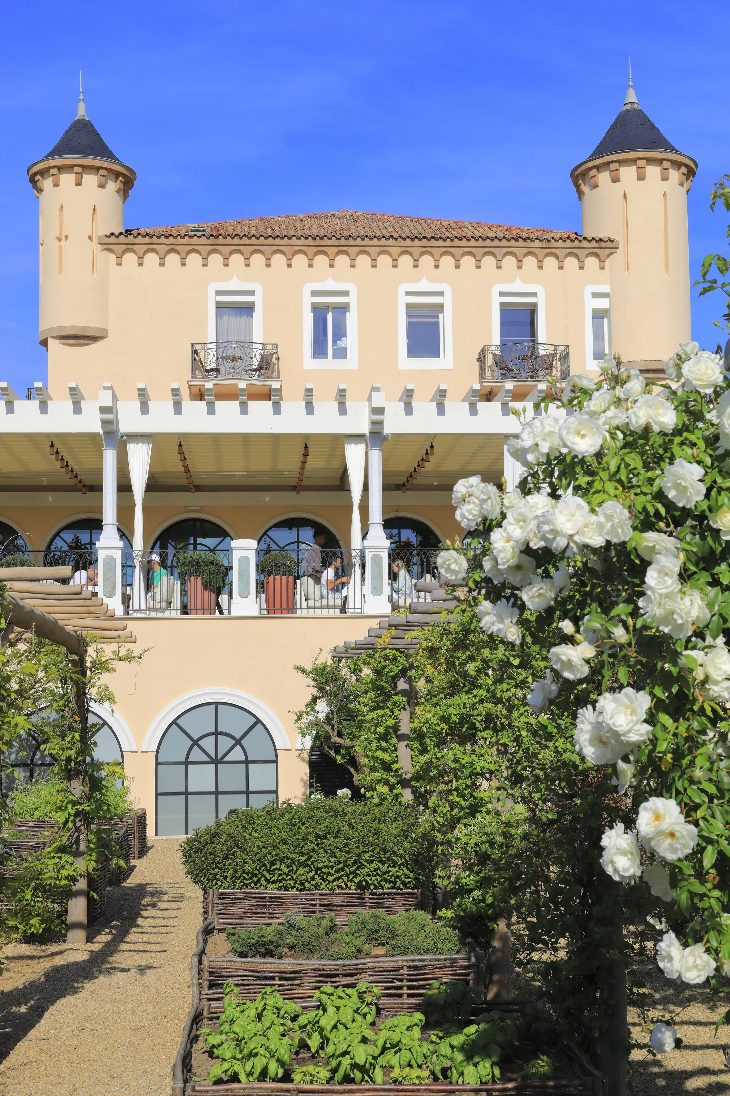 The 19th-century facade of the Chateau de la Messardière hotel in Saint-Tropez, with its restaurant, La Table de La Messardière, visible on a sunny day.