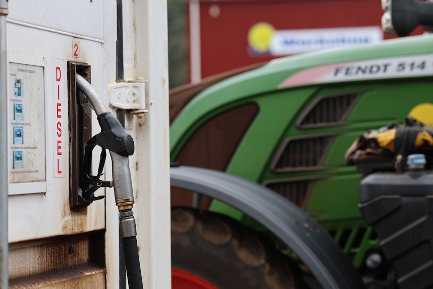 a tractor is parked next to a diesel fuel pump