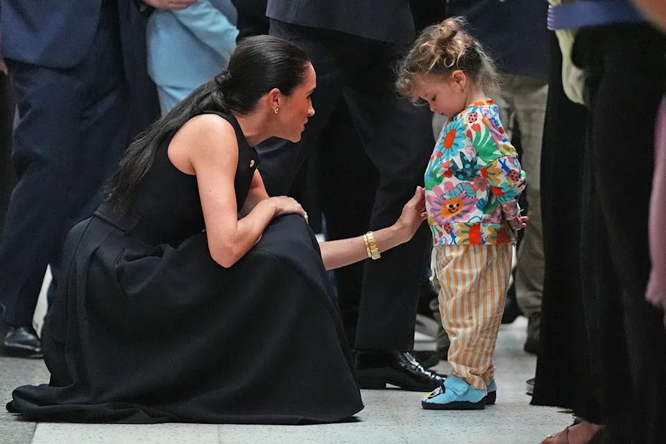Meghan, Duchess of Sussex with a small girlCredit: Jonathan Brady-Pool/Getty