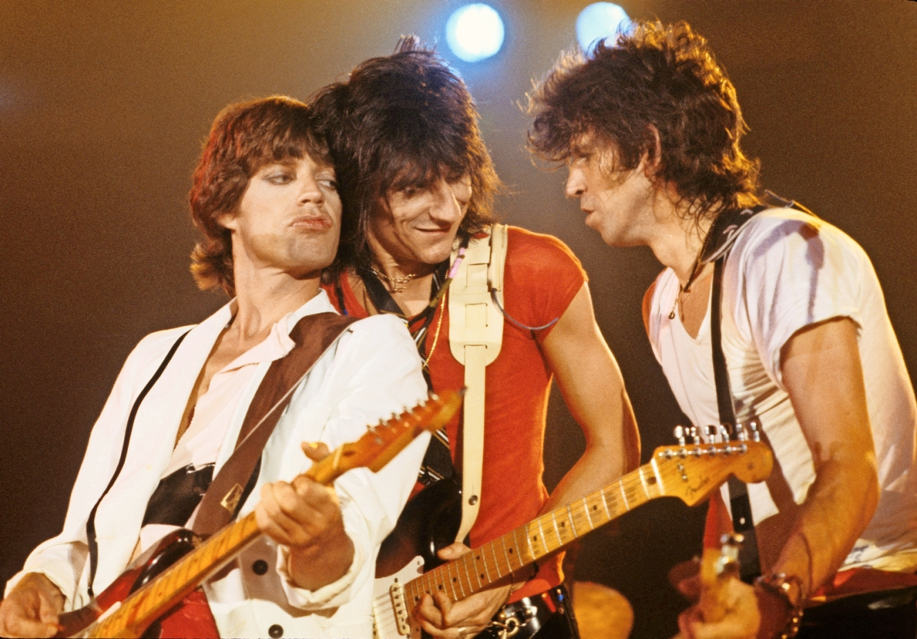 The Rolling Stones, Mick Jagger, Ron Wood, and Keith Richards, perform live onstage with guitars.