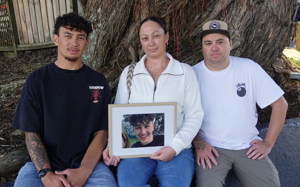 Brother Jordan and parents Alicia Toki and Andre Petera with a photo of Karnin “Tino” Petera outside the Whangārei courthouse.
