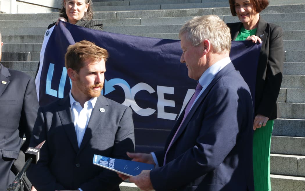 National MP Grant McCallum accepts a petition from ultra-marathon swimmer Jono Ridler to ban bottom trawling.