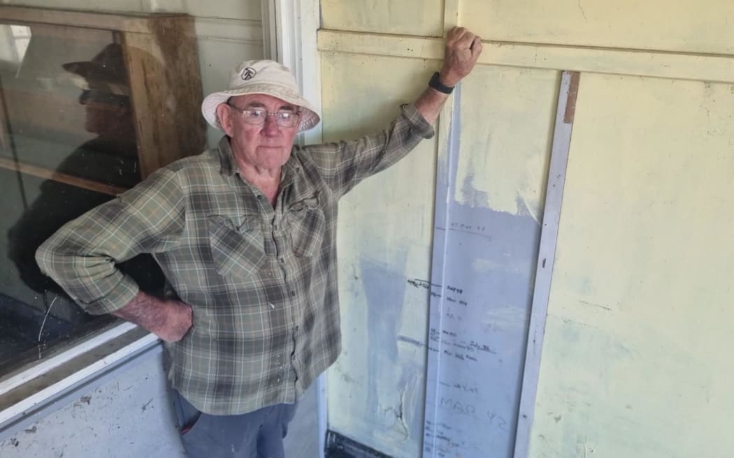Stewart Mckenzie owns the Kallil Motors Building in Ōhura. Built in the 1920s, etched on its wall is a record of all the times floodwaters have entered the building.