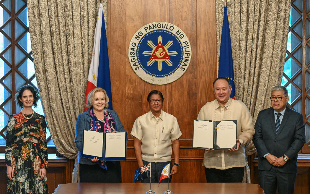 Philippine President Ferdinand Marcos poses with New Zealand's Defence Minister Judith Collins and Philippine Defence Secretary Gilberto Teodoro (2nd R), both holding documents on the newly-signed Status of Visiting Forces Agreement which allows the deployment of troops on each other's territory, as New Zealand's Ambassador to the Philippines Catherine McIntosh (L) and Philippine Foreign Minister Enrique Manalo (R) look on following the signing ceremony at the Malacanang Palace in Manila on April 30, 2025. (Photo by Jam STA ROSA / POOL / AFP)