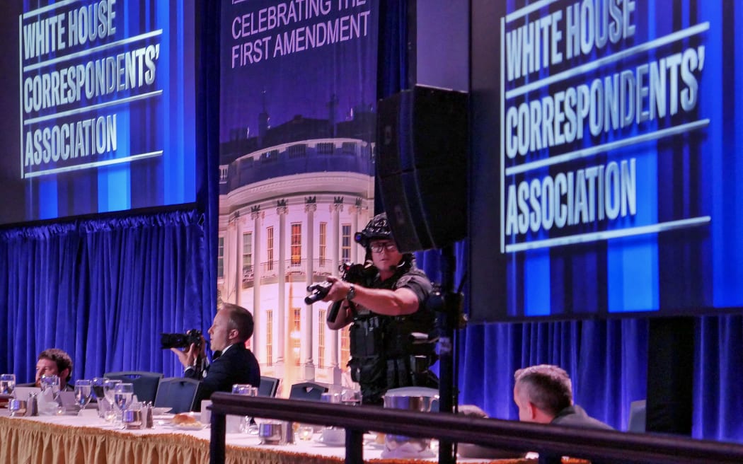 WASHINGTON, DC - APRIL 25: Getty Images photographer Andrew Harnik takes photos as agent points his weapon after an incident at the annual White House Correspondents Association Dinner April 25, 2026 in Washington, DC. According to reports, President Donald Trump, along with other government officials, were evacuated from the Washington Hilton after what sounded like gun fire. Chip Somodevilla/Getty Images/AFP (Photo by CHIP SOMODEVILLA / GETTY IMAGES NORTH AMERICA / Getty Images via AFP)