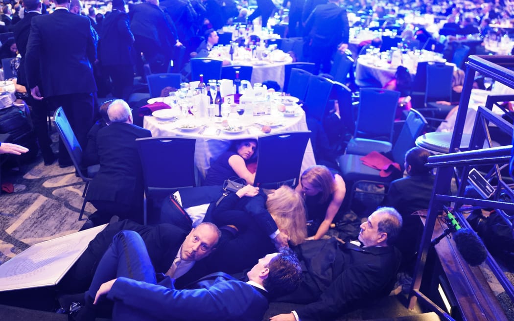 WASHINGTON, DC - APRIL 25: Guests take cover after a un-kown safety event took place as President Donald Trump was to speak to attendees of the annual White House Correspondents Association Dinner April 25, 2026 in Washington, DC. According to reports, President Donald Trump, along with other government officials, were evacuated from the Washington Hilton after what sounded like gun fire. Nathan Howard/Getty Images/AFP (Photo by Nathan Howard / GETTY IMAGES NORTH AMERICA / Getty Images via AFP)
