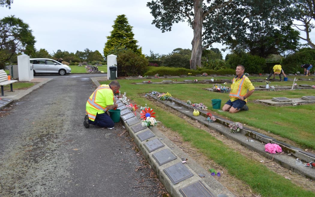 Volunteers clean the gravestones of people who served New Zealand.