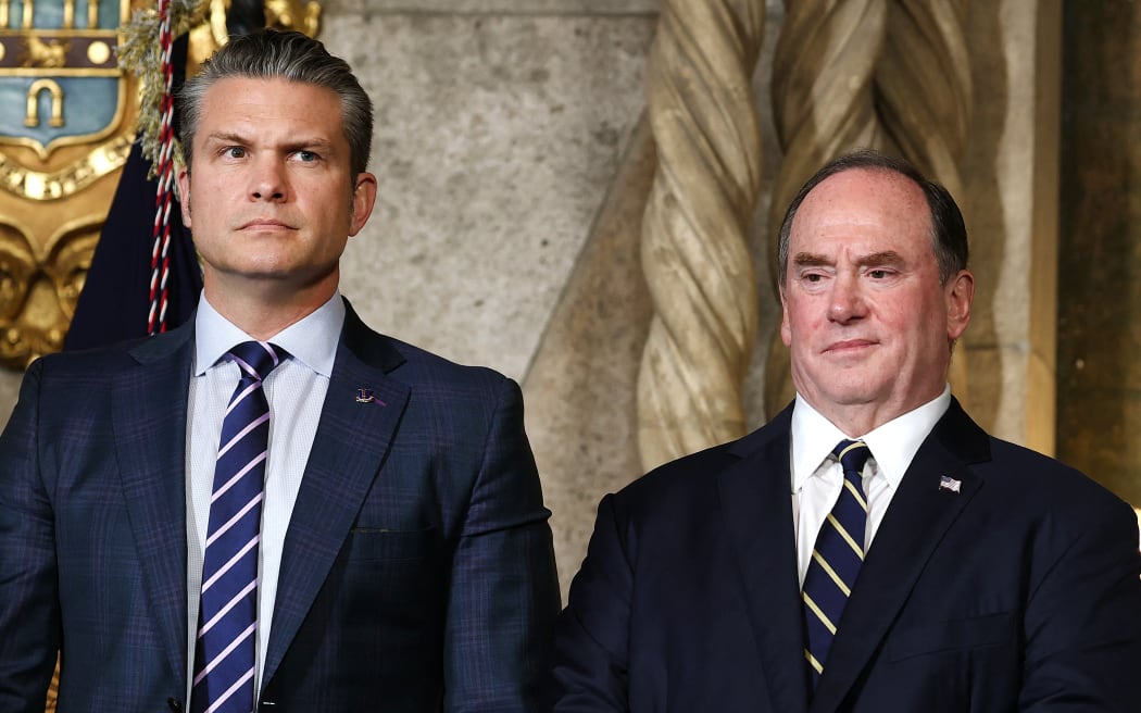 PALM BEACH, FLORIDA - DECEMBER 22: U.S. Secretary of War Pete Hegseth and Secretary of the Navy John Phelan stand together as U.S. President Donald Trump announced the creation of the “Trump-class” battleship during a statement to the media at Trump’s Mar-a-Lago estate on December 22, 2025 in Palm Beach, Florida. Trump announced the new class of ship will become the centerpiece of his “Golden Fleet” program to rebuild and strengthen the U.S. shipbuilding industry. Tasos Katopodis/Getty Images/AFP (Photo by TASOS KATOPODIS / GETTY IMAGES NORTH AMERICA / Getty Images via AFP)