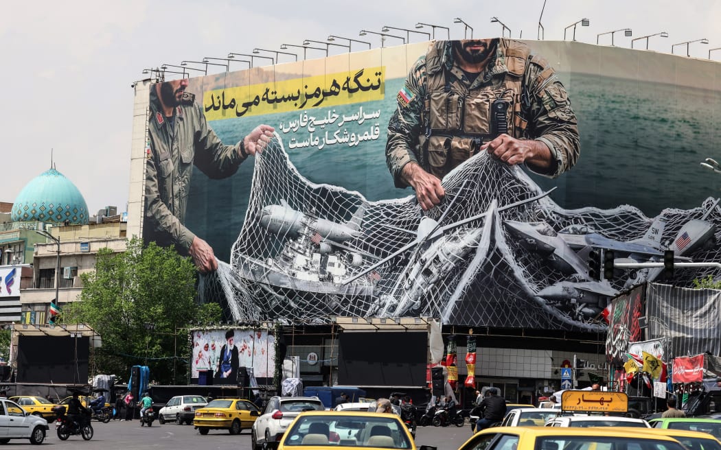 Vehicles drive past a giant billboard reading 'The Strait of Hormuz remains closed' at the Revolution Square in Tehran on April 22, 2026, amid a ceasefire in the region. Pakistan's capital was still locked in gear on April 22, to host high-stakes US-Iran talks that were pushed back at the last minute overnight, but many residents began to tire of the heavy personal and economic toll of tight security restrictions.