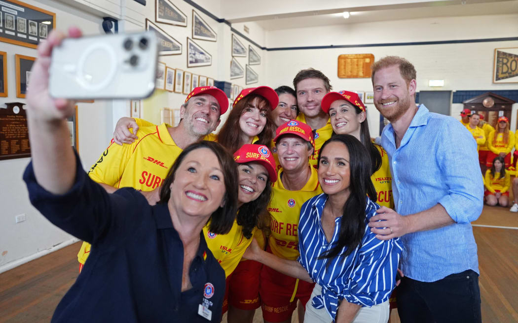 Britain's Prince Harry, Duke of Sussex, and his wife Meghan, the Duchess of Sussex, pose for a photo during a meeting with volunteer first responders from Bondi Surf Bathers' Life Saving Club at Bondi Beach in Sydney on April 17, 2026. (Photo by Jonathan Brady / POOL / AFP)