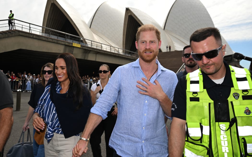 Britain’s Prince Harry, Duke of Sussex, and his wife Meghan, Duchess of Sussex, walk towards the wharf to board a sailing boat at Australia’s iconic Sydney Opera House on April 17, 2026. (Photo by Saeed KHAN / AFP)