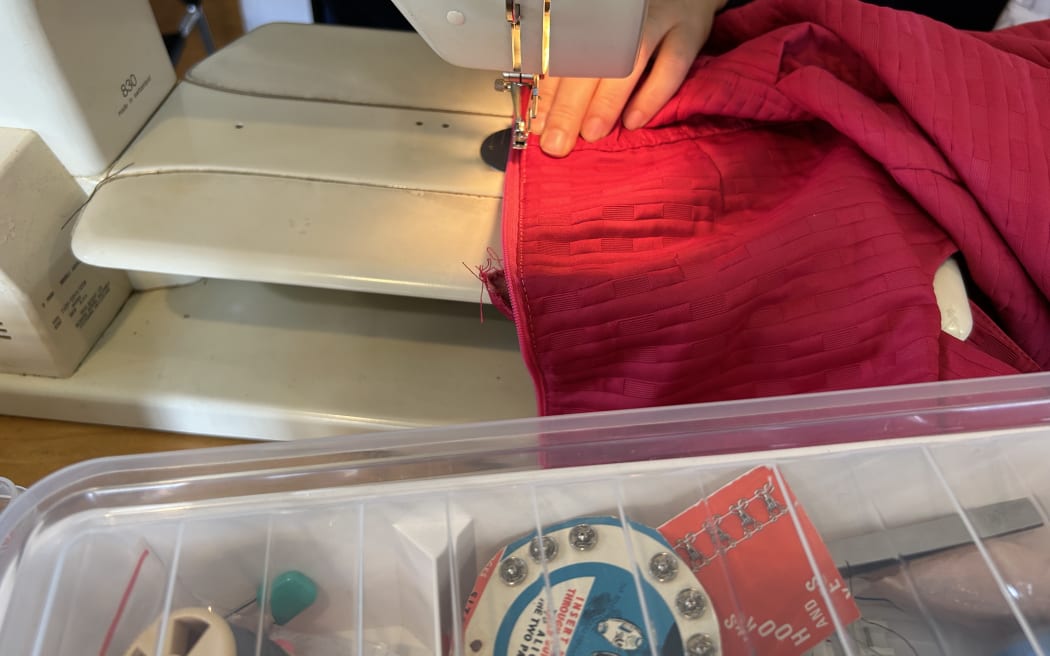 Picture depicts a zip is being stitched on with a sewing machine
