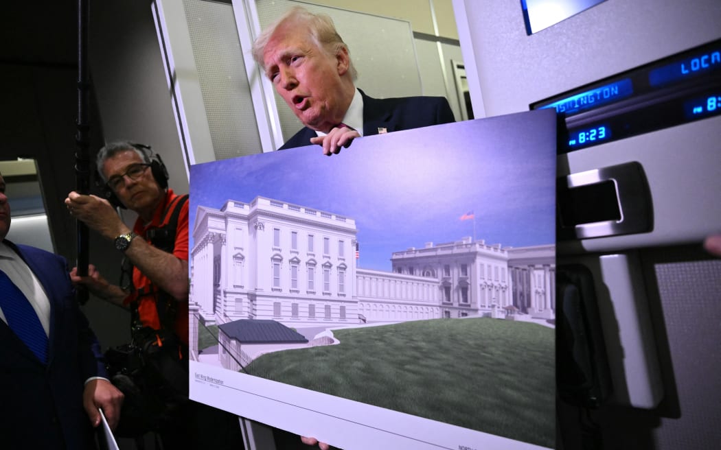 (FILES) US President Donald Trump holds a rendering of the East Wing modernization as he speaks to reporters aboard Air Force One en route to Joint Base Andrews, Maryland, on March 29, 2026. A US judge on March 31, 2026, ordered a halt to construction of President Donald Trump's massive White House ballroom, which has already seen the historic East Wing completely torn down. Trump is "steward" of the White House but "he is not, however, the owner!" wrote Judge Richard Leon, saying that congressional approval would be needed for the project. Leon was ruling in response to a legal challenge from the National Trust for Historic Preservation in the United States, a nonprofit organization which seeks to protect historic buildings. (Photo by Mandel NGAN / AFP)